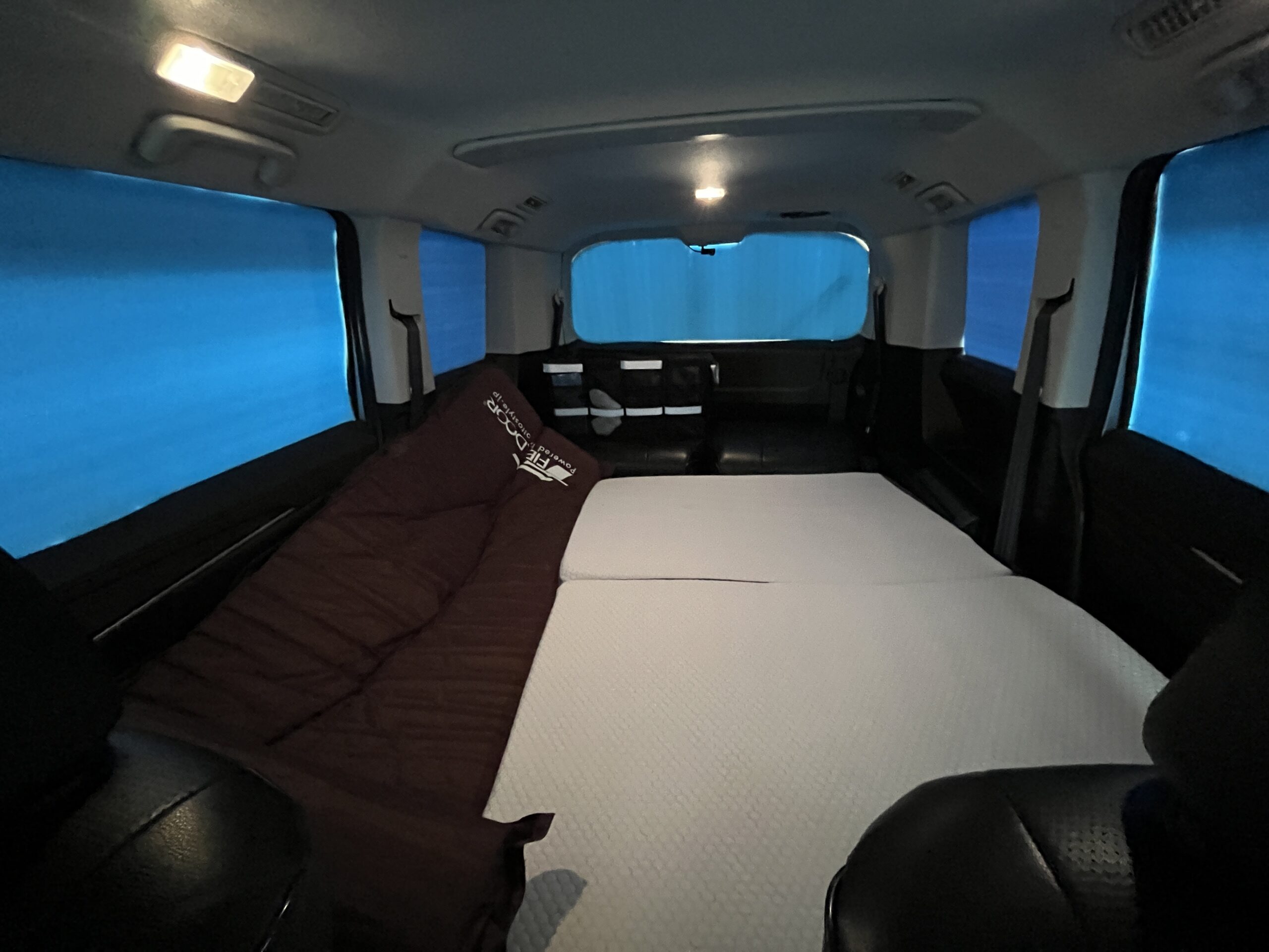 車内にFIELDOORの茶色いマットと白いマットレスを配置した寝床