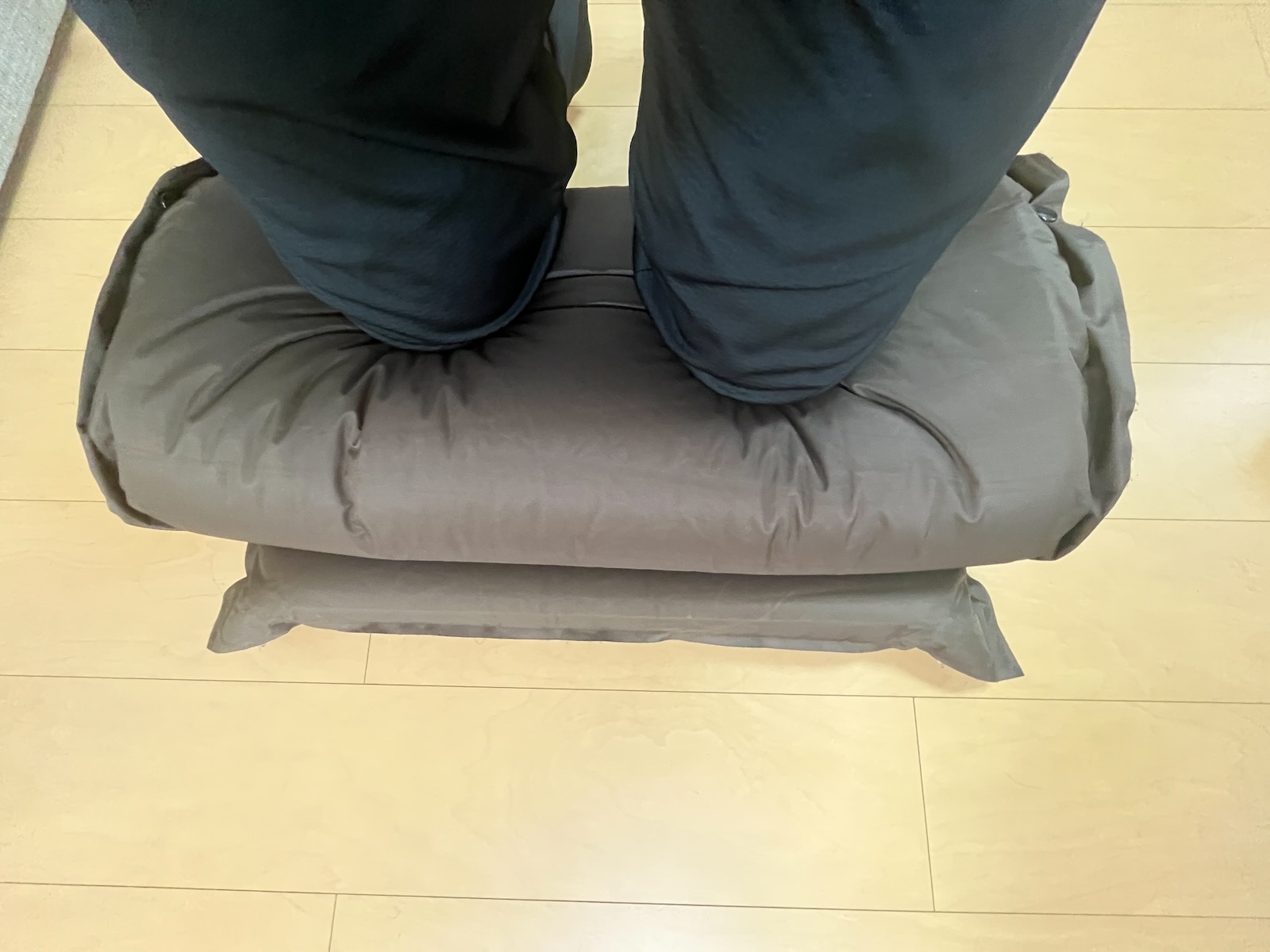 丸めたマットに膝を載せて体重をかけている様子