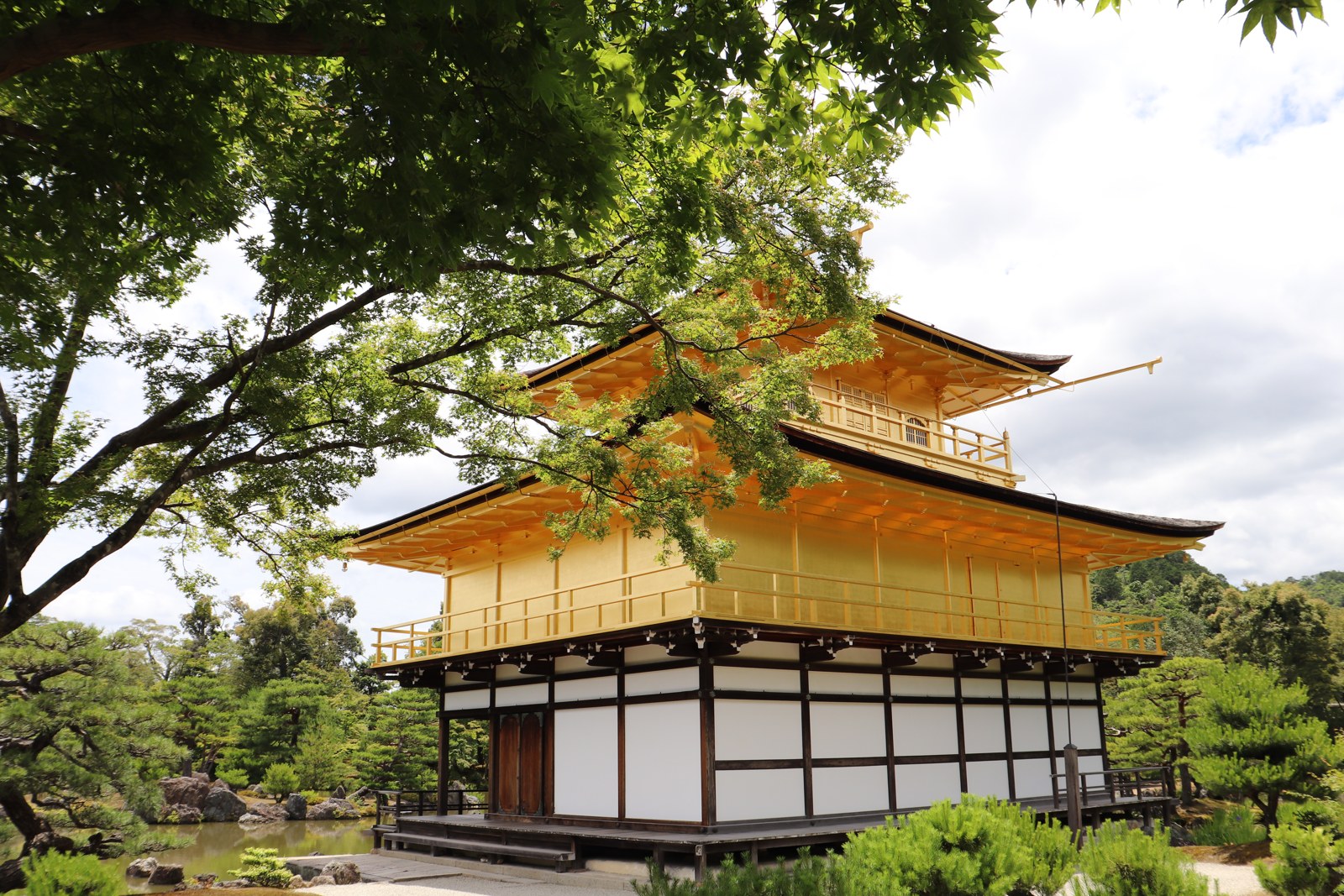 木々のそばから見た金閣寺の舎利殿の外観