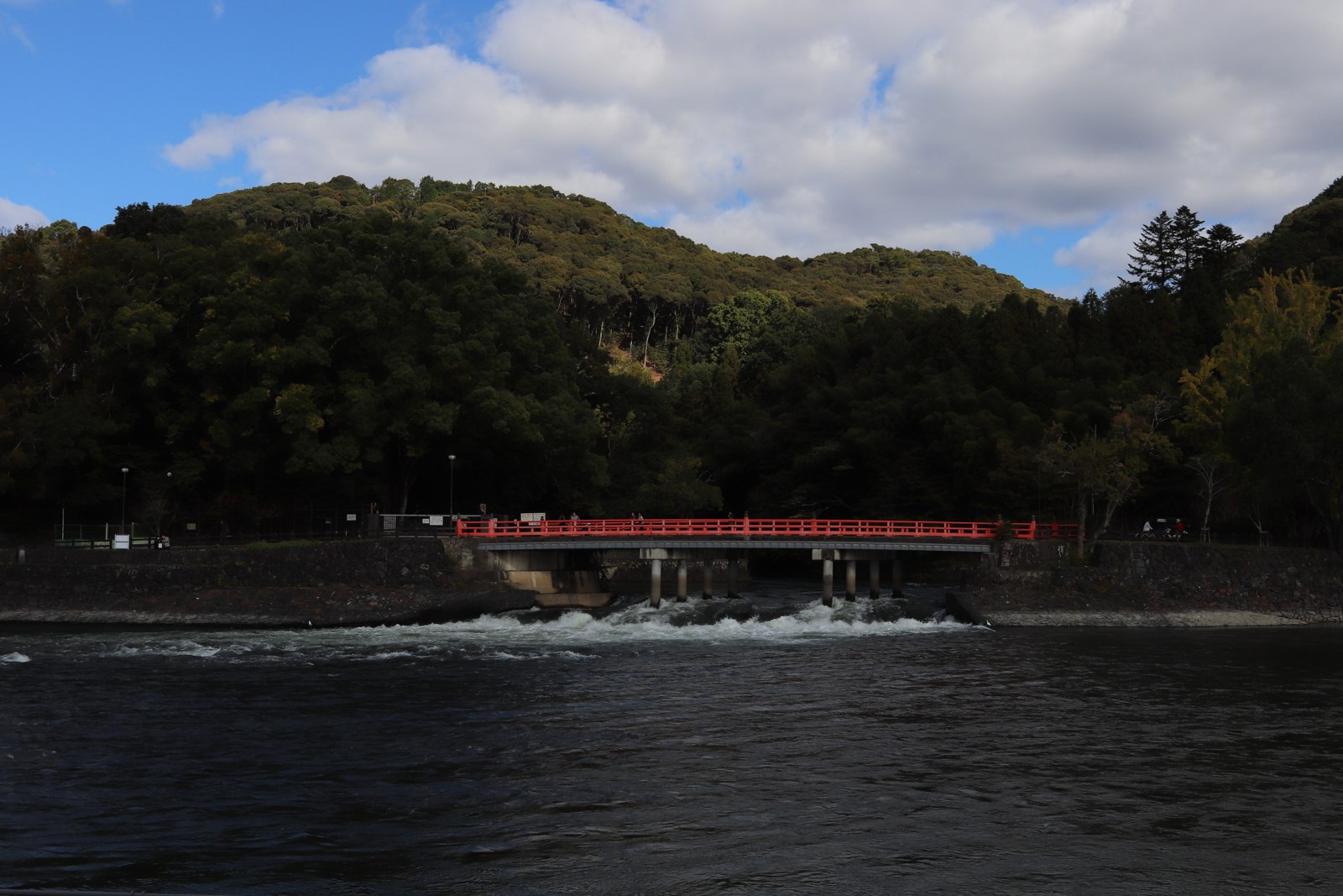 宇治川に架かる朱色の朝霧橋と背後の山並み